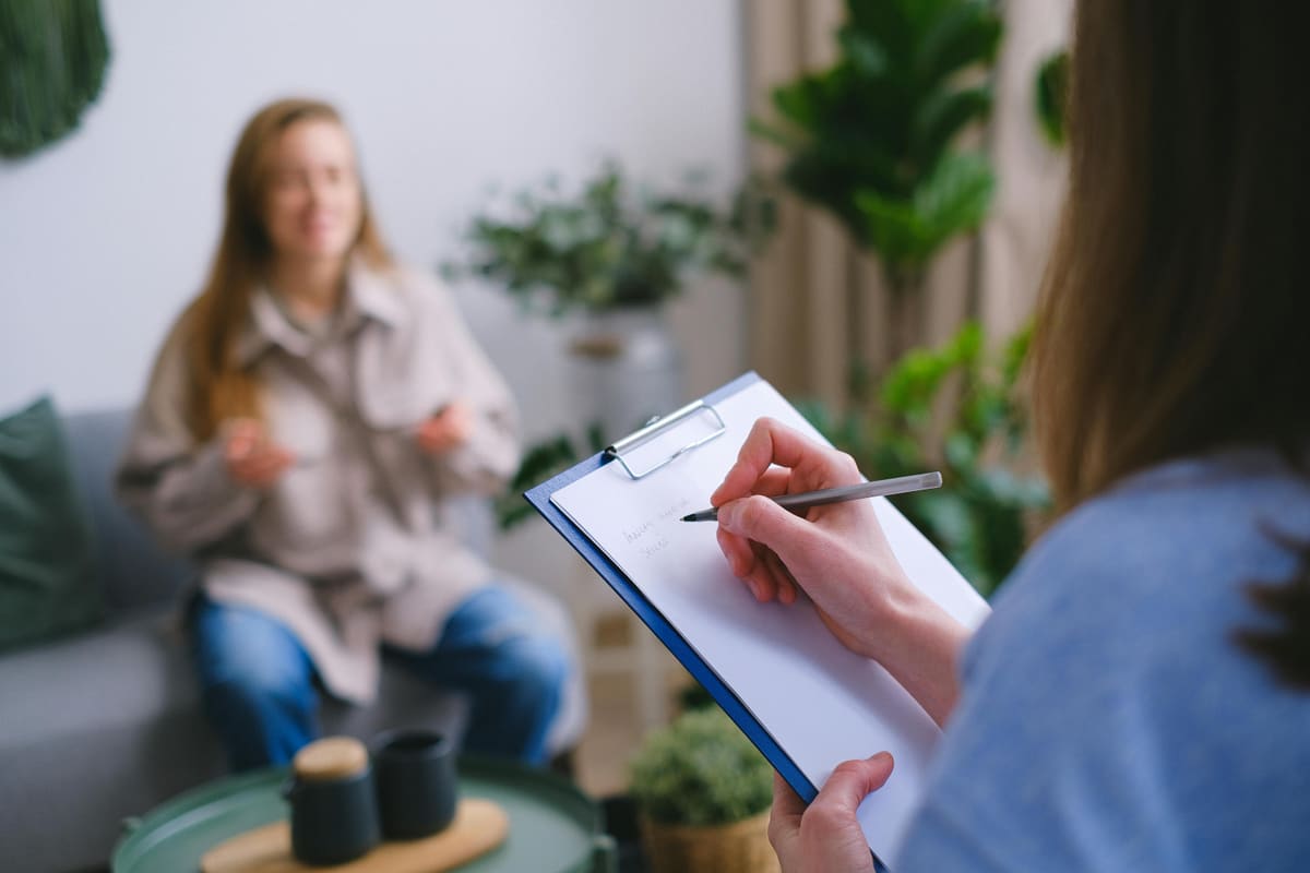 Counselor taking notes during a treatment session